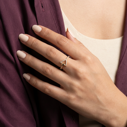 خاتم ذهب عيار 18 بتصميم مثلث مرصع، يظهر اللمعان والتفاصيل الدقيقة في الصورة.