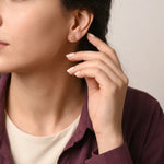 أقراط عيار 18 من غمية بتصميم زهرة مزخرفة، تظهر التفاصيل الدقيقة والأناقة في الصورة.